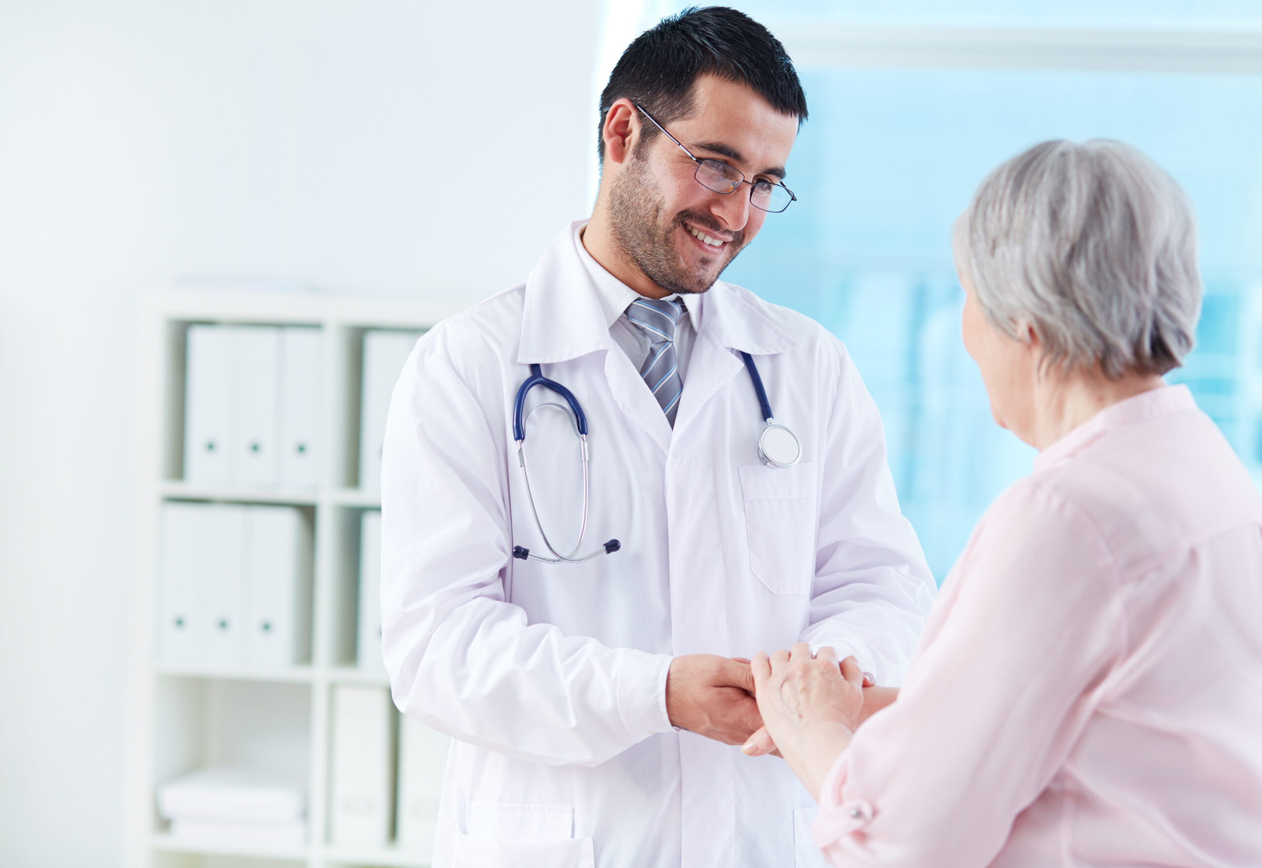 a young doctor helping an old patient
